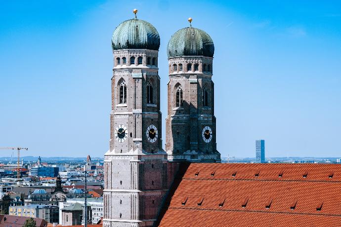 two towers on top of a building with a city in the background